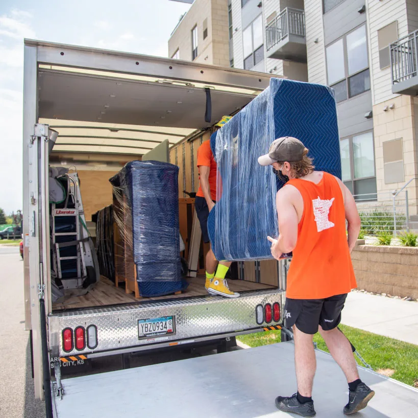 A College Muscle Movers crew loading furniture into a truck in St Paul, MN
