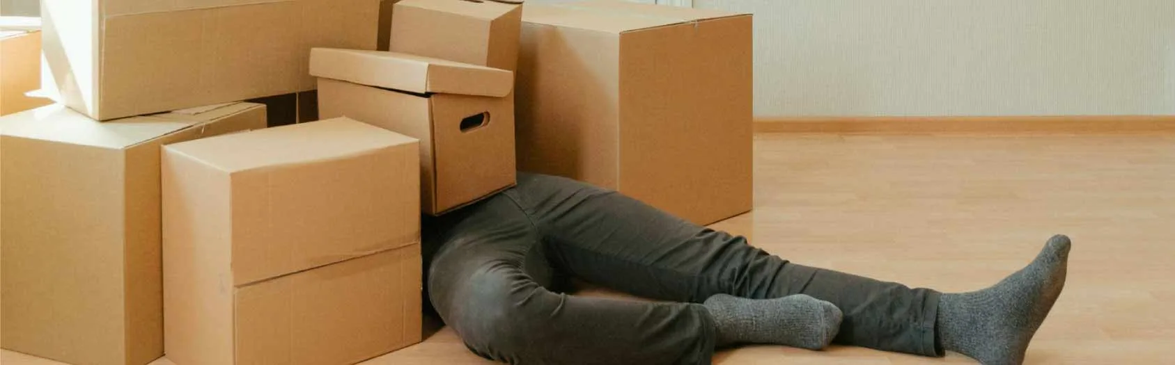 A person buried under a pile of moving boxes