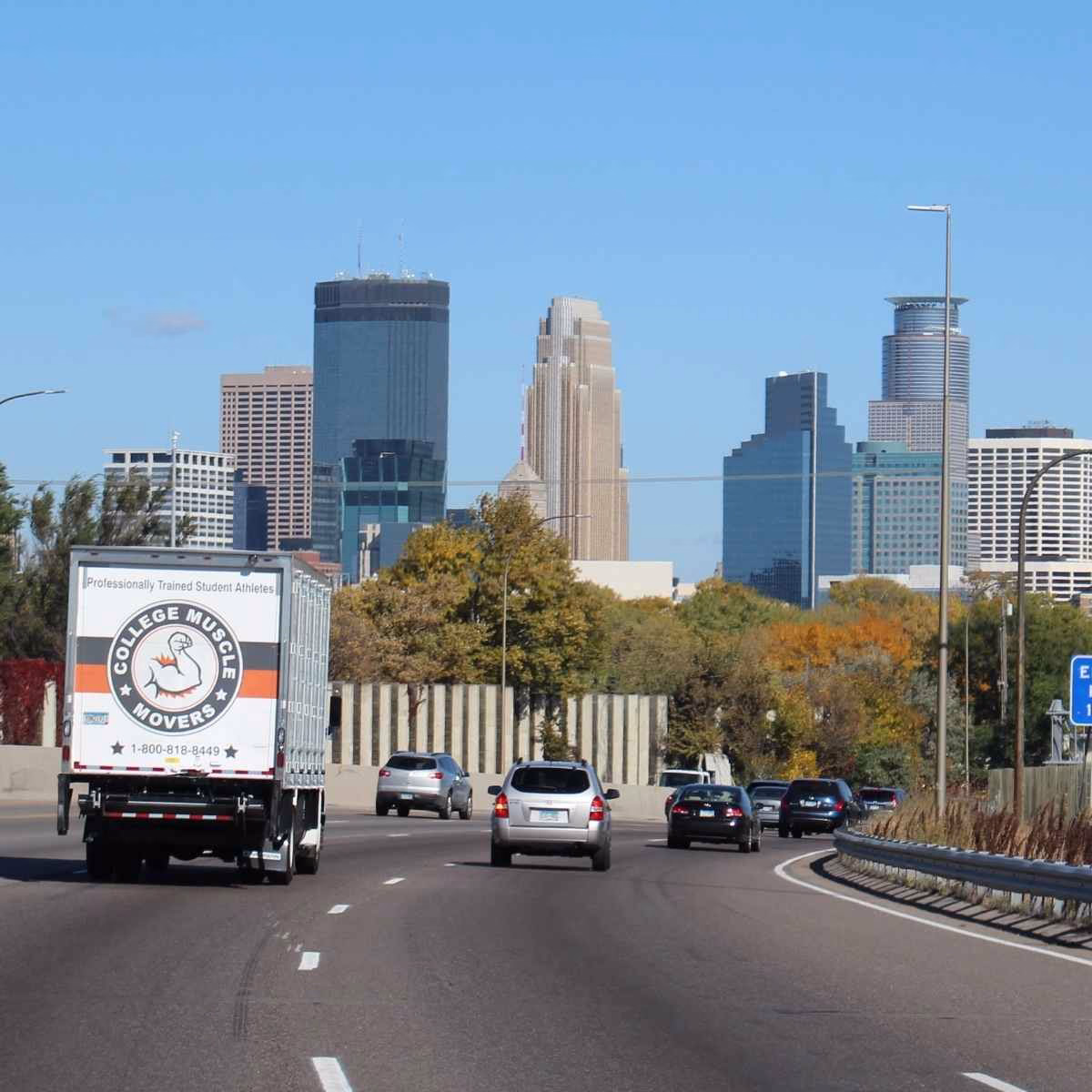 A College Muscle Movers truck driving on 35W past downtown Minneapolis, MN