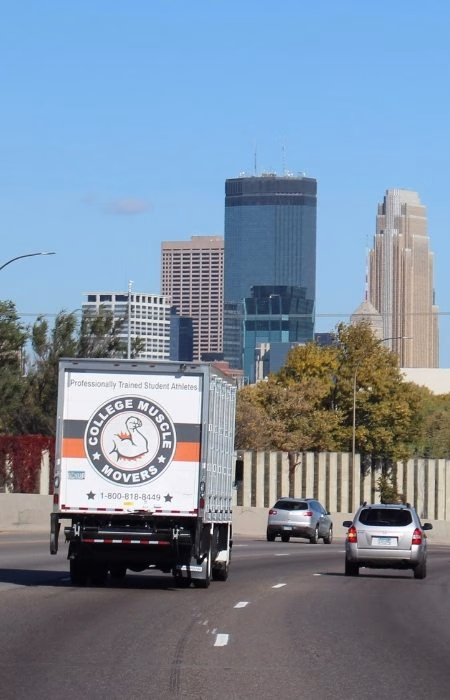 A College Muscle Movers truck driving on 35W past downtown Minneapolis, MN