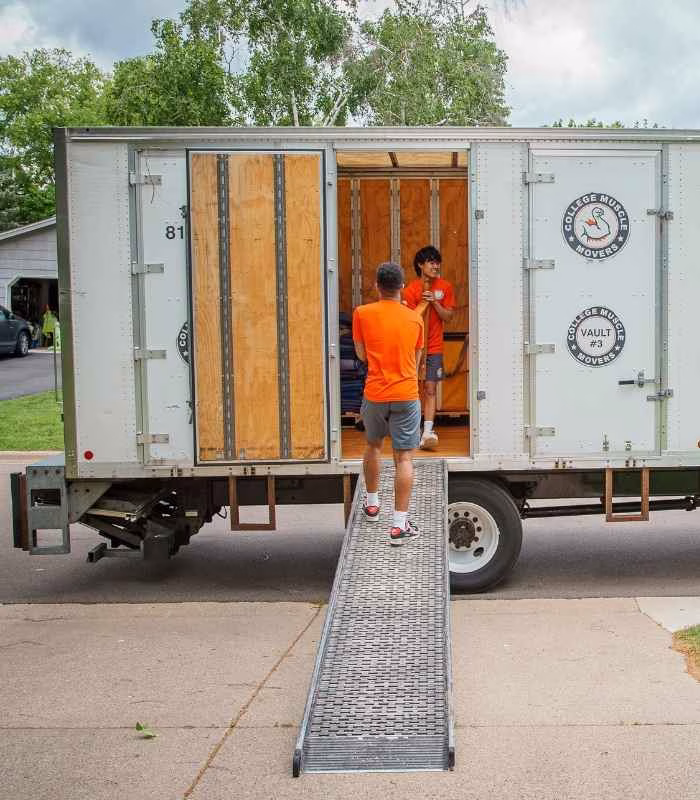 How Vault Storage Works Two movers unloading furniture from a vault storage truck at a house in the Twin Cities.