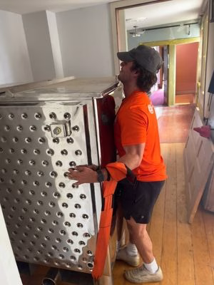 A College Muscle Movers employee lifting a heavy specialty item.