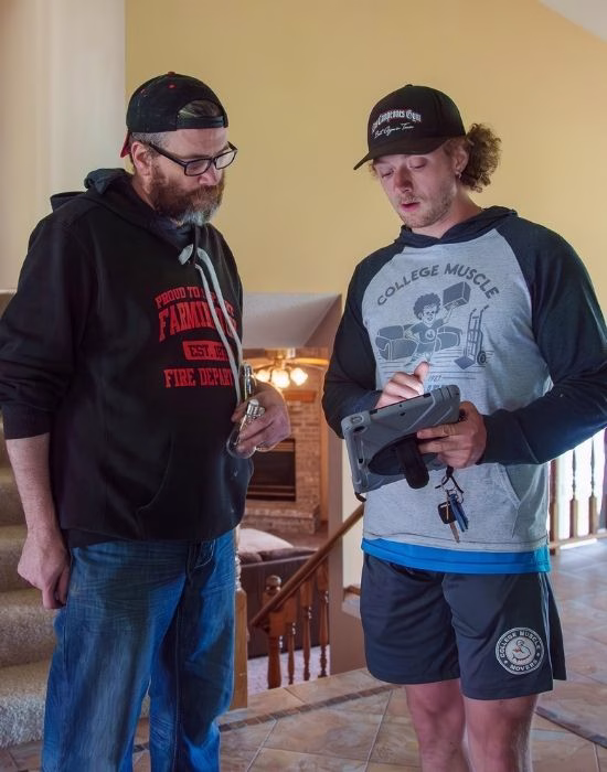 A customer tipping a College Muscle Movers crew after a moving job