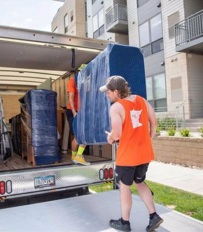 A College Muscle Movers crew moving furniture into a truck outside an apartment in Shoreview, MN