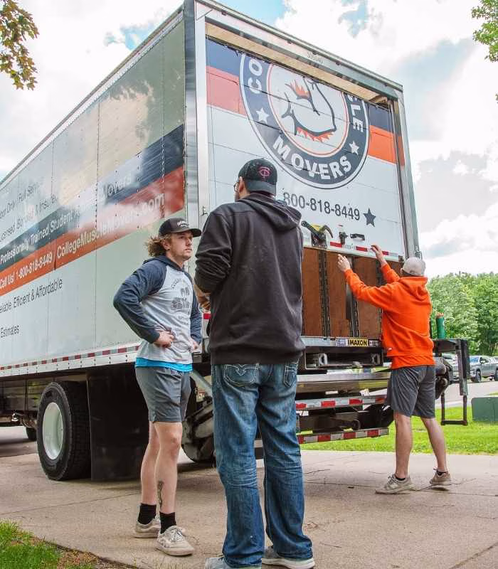 A College Muscle Movers crew greeting a customer in the driveway of a house in the Shoreview, MN.